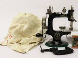 a small sewing machine with a cloth bag on the table