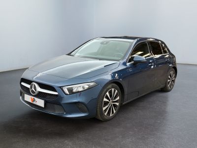 a blue mercedes cla parked in a room with a black floor