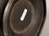 a black vase sitting on a table with a tag on it