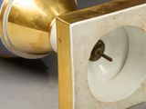 a white and gold vase sitting on a table