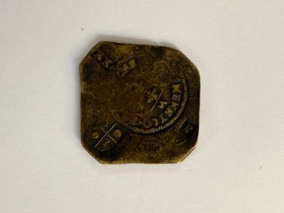 une vieille pièce posée sur une surface blanche