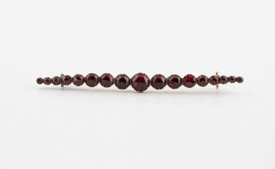 a close up of a bracelet with garnets on a white surface