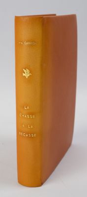 un livre orange posé sur une table près d'un mur blanc