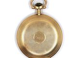 an old gold pocket watch on a white surface with a white background