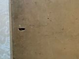 a hole in the wall of a bathroom with a toilet