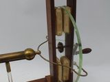 a clock that is on a wooden stand with a wire