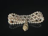 pearl necklace with a gold clasp and a large pearl bead