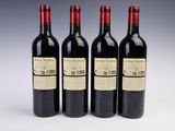 three bottles of wine are lined up on a white surface