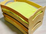 un lit en bois pour enfant sur lequel est posé un oreiller jaune