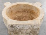 a stone bowl that is sitting on the floor