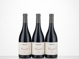 three bottles of wine sitting on top of a table next to each other