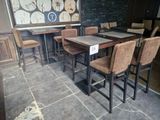 tables and chairs are lined up in a restaurant with a clock on the wall