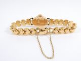 an image of a gold bracelet with a chain attached to it