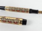 a pair of fountain pens with gold and black trims