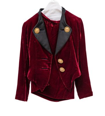 un gros plan d'une veste rouge suspendue à un cintre sur fond blanc
