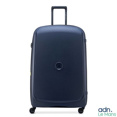 La valise bleue repose sur ses roulettes, posée sur une surface blanche.