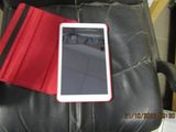 a tablet sitting on a black leather chair with a red cover
