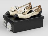 a pair of white and black shoes sitting on top of a black box