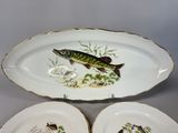 three plates with fish designs on them are sitting on a table