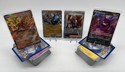 quatre types différents de cartes Pokémon exposées sur une surface blanche