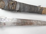 pair of old knifes on a white surface with rust on them