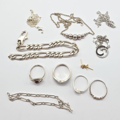 Plusieurs types de bijoux sont disposés sur une surface blanche