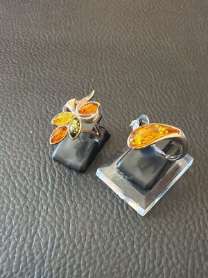 a pair of earrings that are sitting on a leather surface