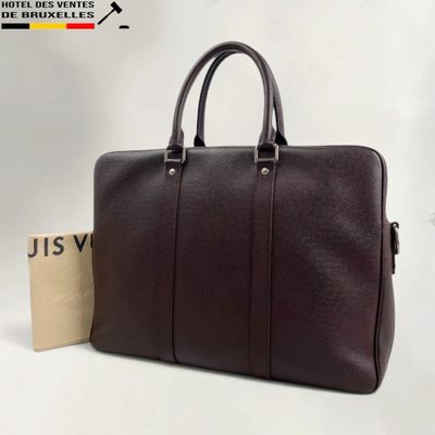 a brown leather briefcase with a tag on the side of it