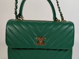 a green handbag with a chain strap and a gold clasp
