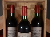 three bottles of wine sitting in a wooden box