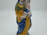 figurine d'une femme tenant un enfant dans ses bras