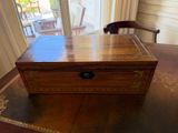 une boîte en bois posée sur une table devant une fenêtre