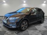 un SUV Nissan noir garé sur un sol à damier dans un garage