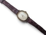 an image of a close up of a wrist watch on a white surface