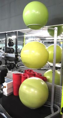 a gym room with a variety of exercise balls on the floor
