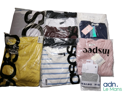 beaucoup de vêtements rangés dans des sacs posés sur la table