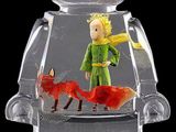 a lego figure that is holding a fish in it ' s mouth
