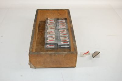 un paquet de cigarettes posé par terre à côté d'une télécommande