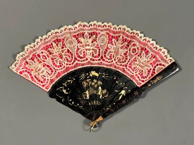 un éventail noir et rouge orné d'un motif doré