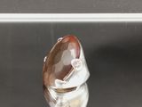 une photo d'une bague sertie d'une pierre marron