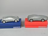 two toy cars sitting on top of a red and blue box
