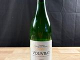 une bouteille de vin blanc posée sur une table en bois
