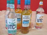 Plusieurs bouteilles d'alcool sont alignées sur une table en bois