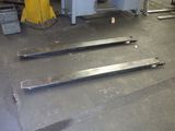 three pieces of metal sitting on the floor in a warehouse