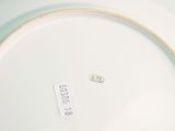 a white plate with a gold rim and a label on it