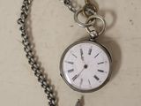 a silver pocket watch with a chain attached to it