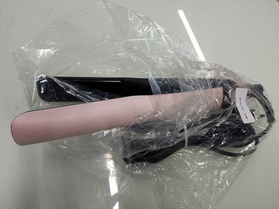 un sèche-cheveux emballé dans du plastique, posé sur une table