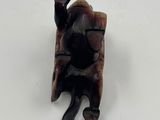 an image of a wooden figurine of a man holding a sword