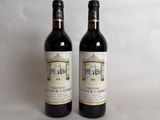 two bottles of wine sitting next to each other on a table