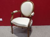 an image of a chair with a white upholstered seat in front of a red wall
